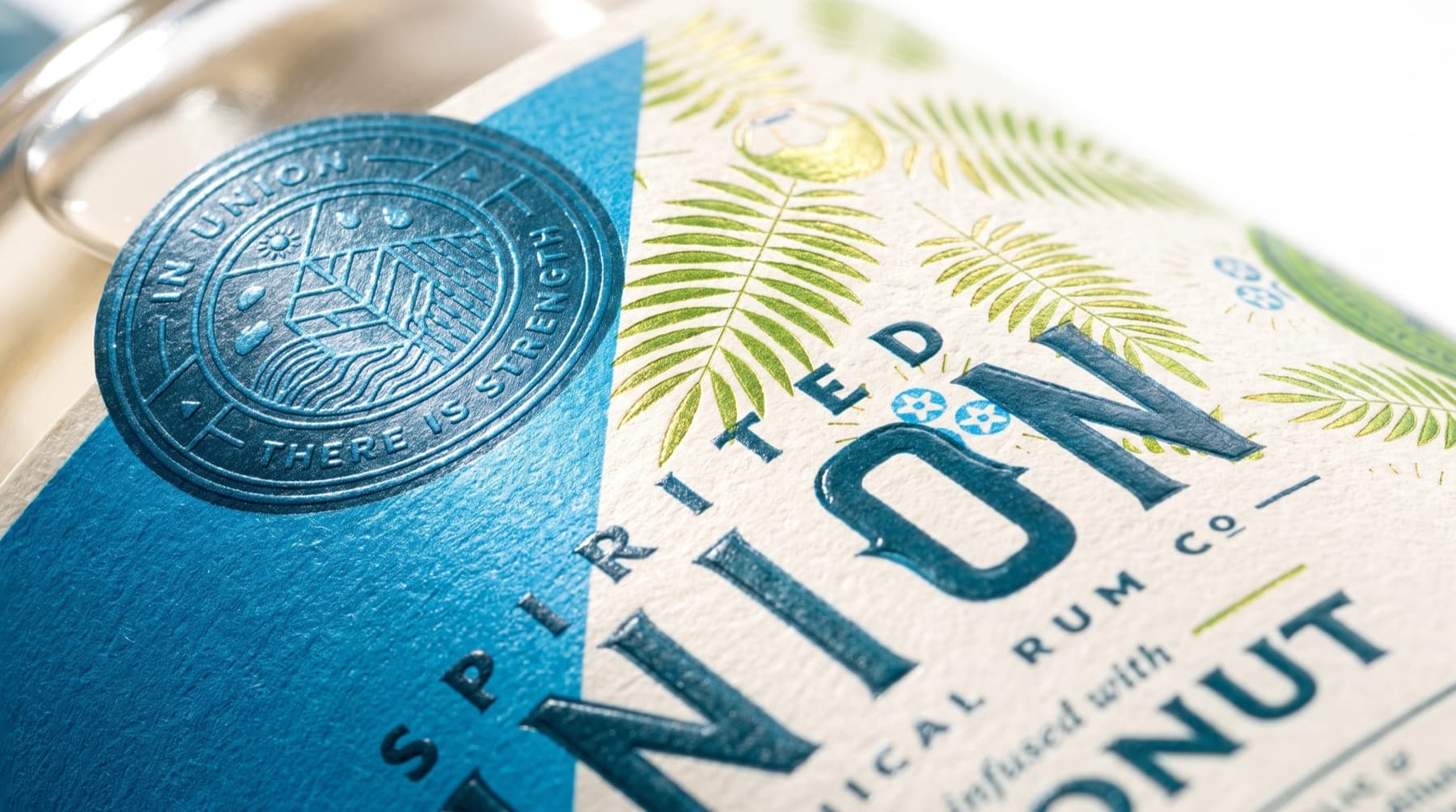 Embossed foil seal on the Spirited Union coconut rum label